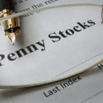 Page of newspaper with words penny stocks. high return penny stocks